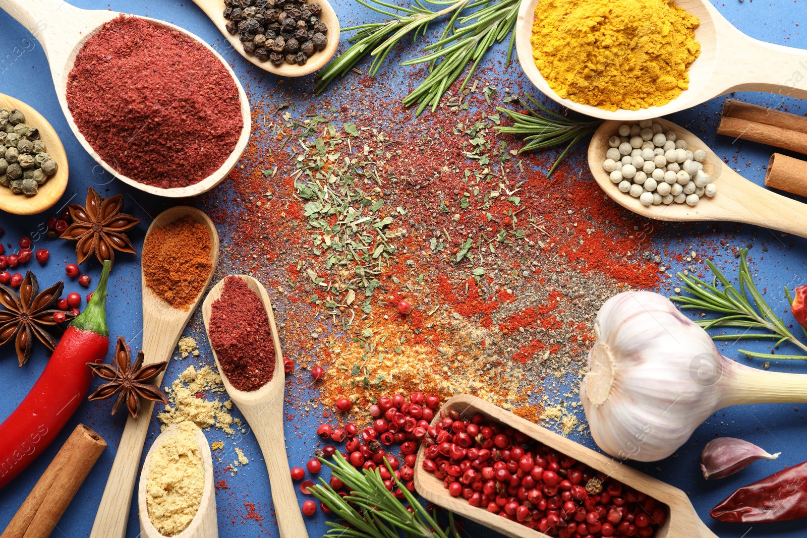 Different aromatic spices on blue background, flat lay Photo of Different aromatic spices on blue background, flat lay