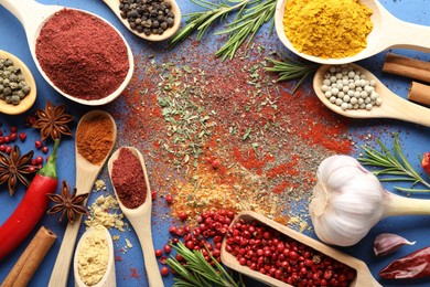 Photo of Different aromatic spices on blue background, flat lay
