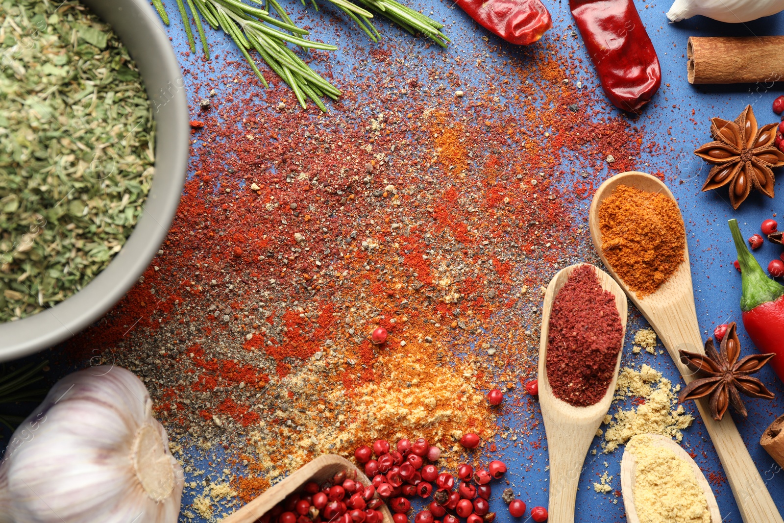 Different aromatic spices on blue background, flat lay Photo of Different aromatic spices on blue background, flat lay