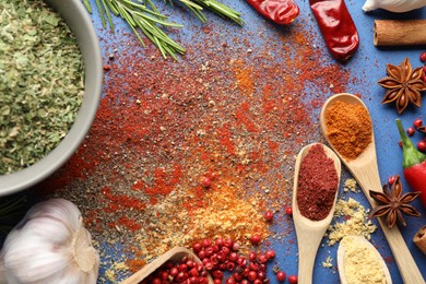 Photo of Different aromatic spices on blue background, flat lay