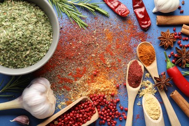 Photo of Different aromatic spices on blue background, flat lay