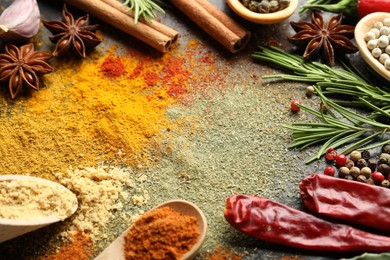 Photo of Different aromatic spices on black background, closeup