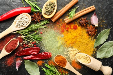 Photo of Different aromatic spices on black background, flat lay