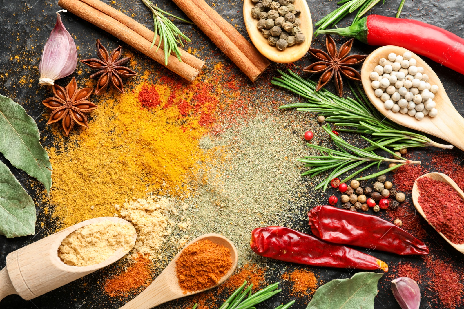 Different aromatic spices on black background, flat lay Photo of Different aromatic spices on black background, flat lay