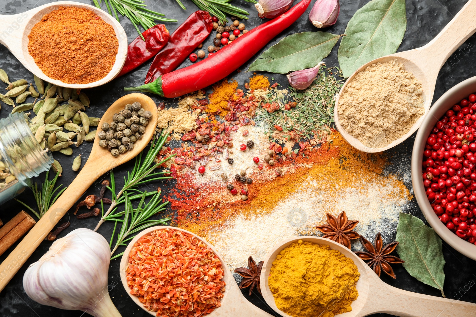 Different aromatic spices on black background, flat lay Photo of Different aromatic spices on black background, flat lay