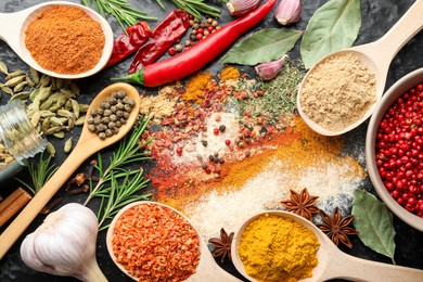 Photo of Different aromatic spices on black background, flat lay