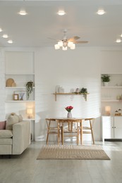 Photo of Stylish dining table with chairs and comfortable sofa in room. Interior design