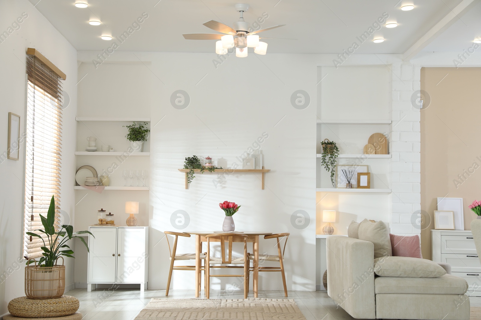 Stylish dining table with chairs and comfortable sofa in room. Interior design Photo of Stylish dining table with chairs and comfortable sofa in room. Interior design