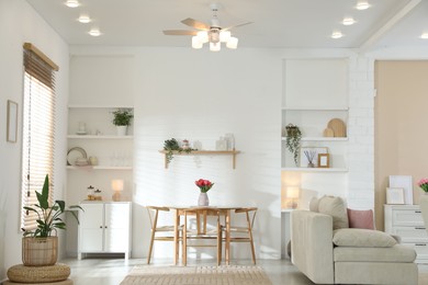 Photo of Stylish dining table with chairs and comfortable sofa in room. Interior design