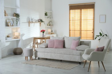 Photo of Comfortable sofa with cushions in room. Interior design