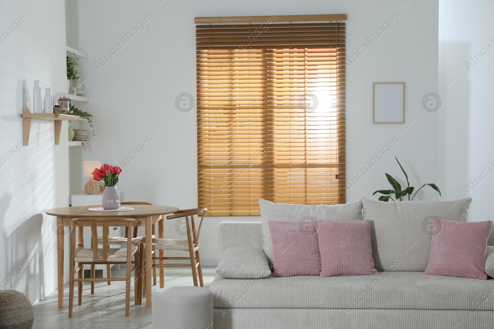 Stylish dining table with chairs and comfortable sofa in room. Interior design Photo of Stylish dining table with chairs and comfortable sofa in room. Interior design