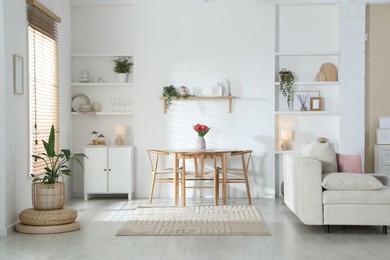 Photo of Stylish dining table with chairs and comfortable sofa in room. Interior design