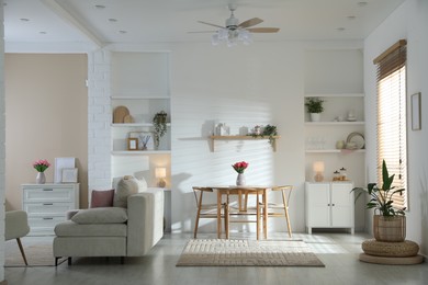 Photo of Stylish dining table with chairs and comfortable sofa in room. Interior design