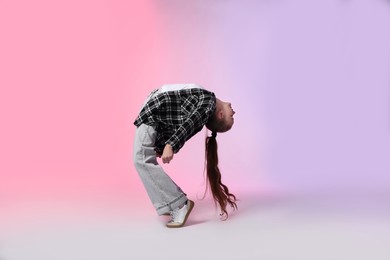 Photo of Girl in stylish clothes dancing on color background