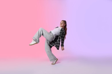 Photo of Girl in stylish clothes dancing on color background