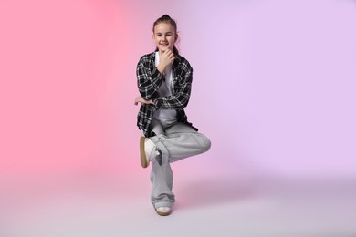 Photo of Girl in stylish clothes dancing on color background