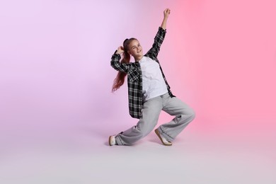 Photo of Girl in stylish clothes dancing on color background