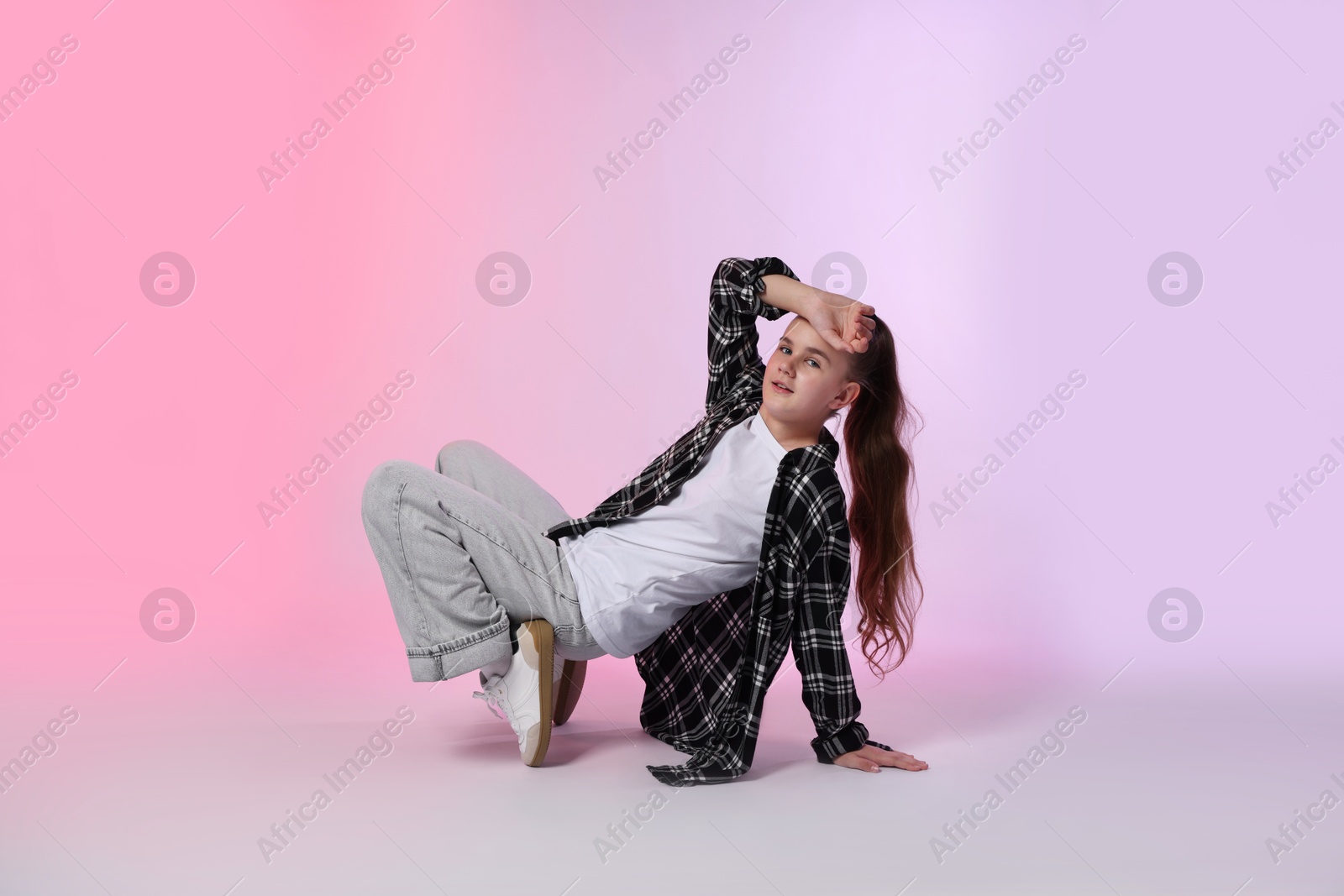 Girl in stylish clothes dancing on color background Photo of Girl in stylish clothes dancing on color background