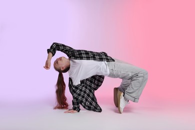 Photo of Girl in stylish clothes dancing on color background