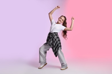 Photo of Girl in stylish clothes dancing on color background