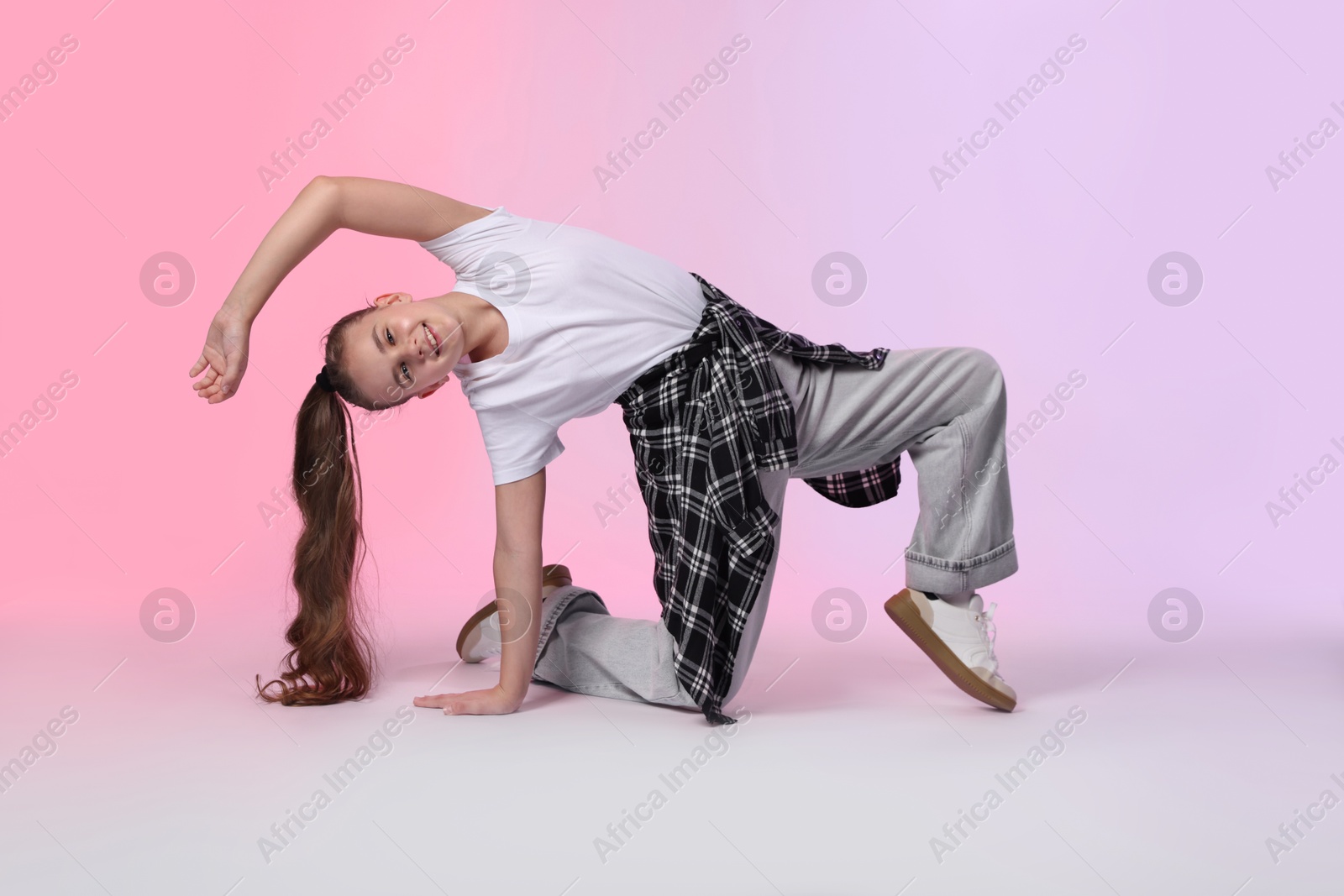 Girl in stylish clothes dancing on color background Photo of Girl in stylish clothes dancing on color background