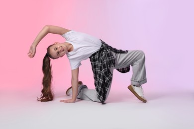 Photo of Girl in stylish clothes dancing on color background