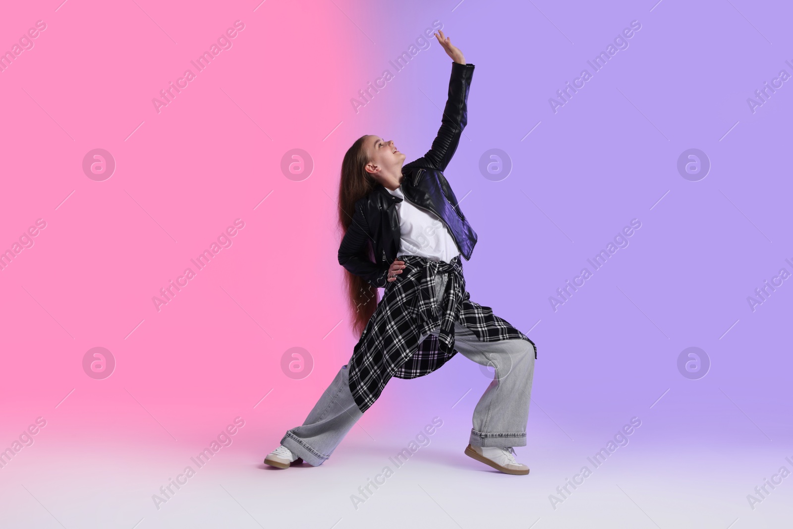 Photo of Girl in stylish clothes dancing on color background