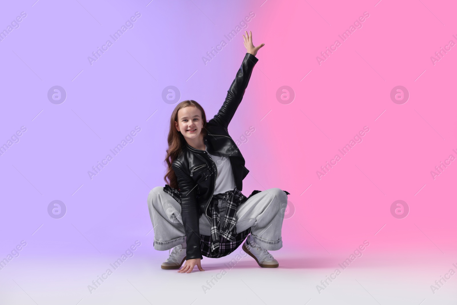 Girl in stylish clothes dancing on color background Photo of Girl in stylish clothes dancing on color background