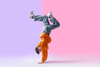 Photo of Boy in stylish clothes dancing on color background