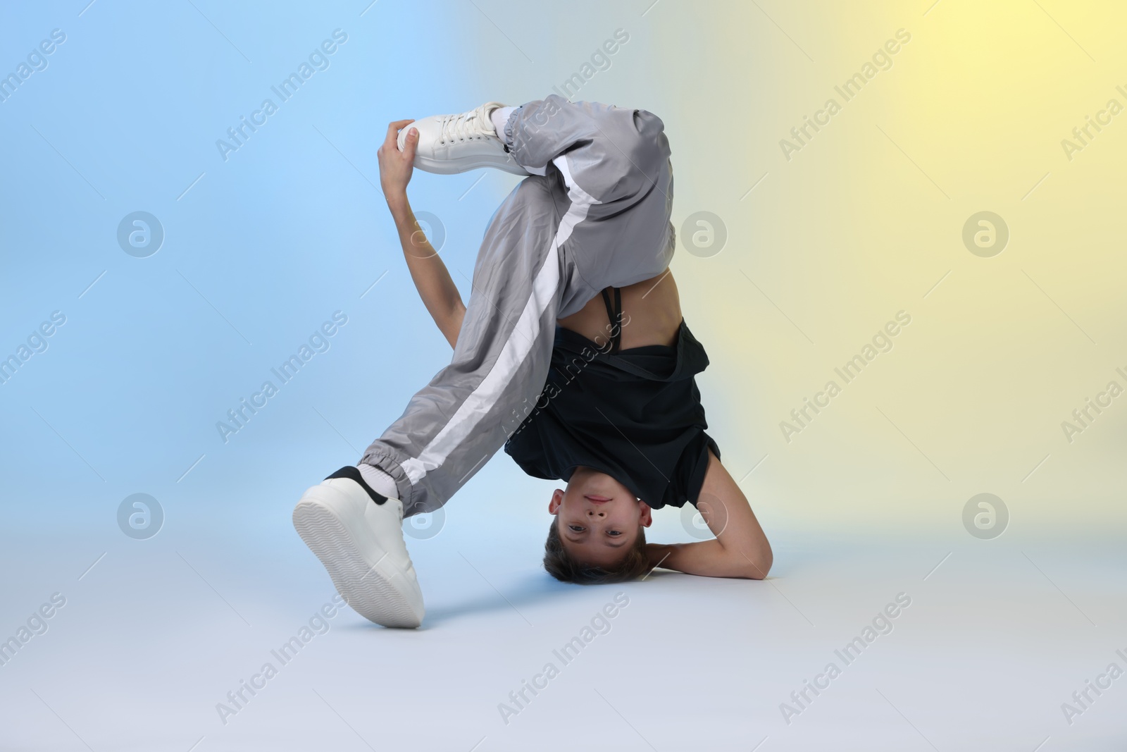 Boy in stylish clothes dancing on color background Photo of Boy in stylish clothes dancing on color background