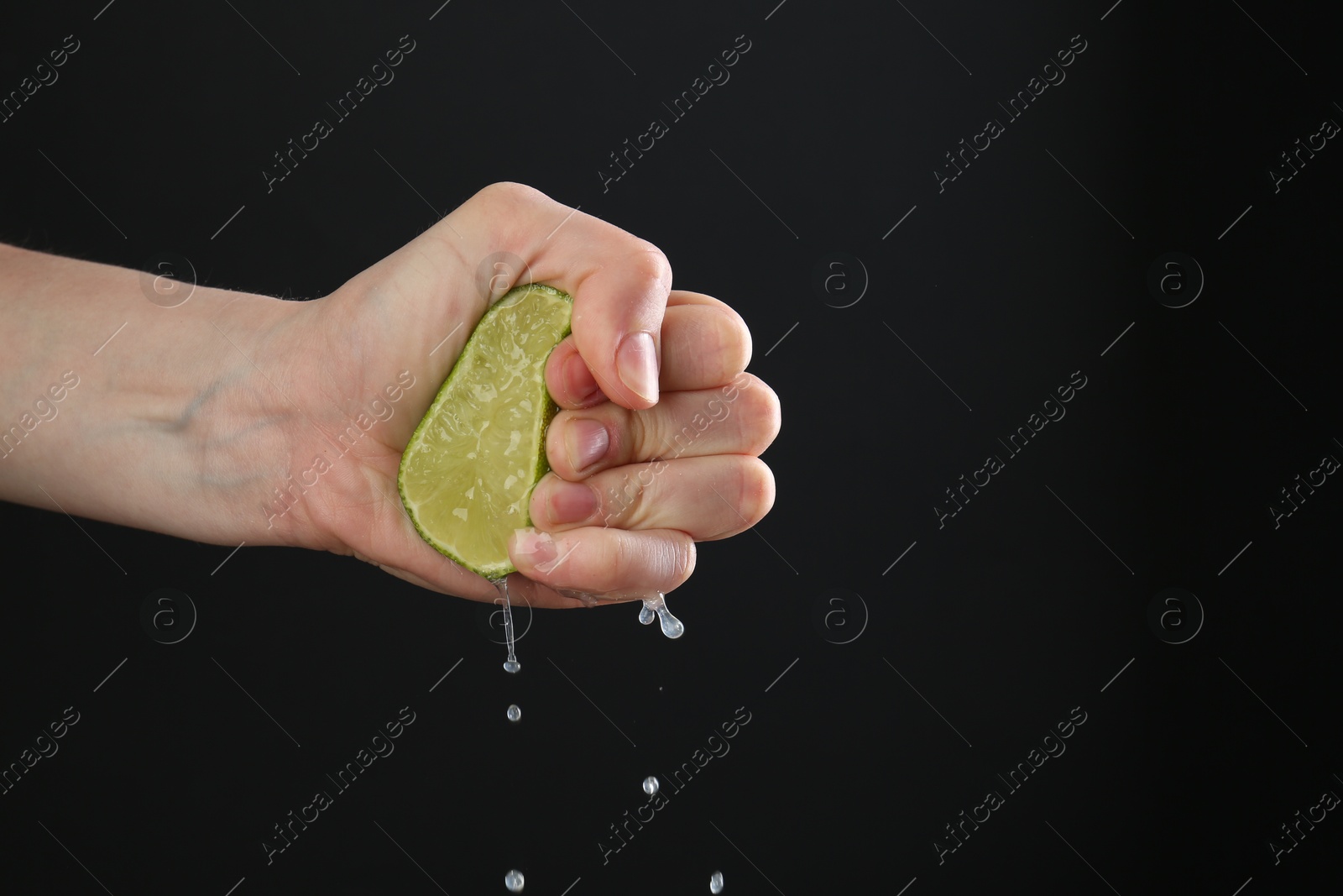 Woman squeezing lime on black background, closeup. Space for text Photo of Woman squeezing lime on black background, closeup. Space for text