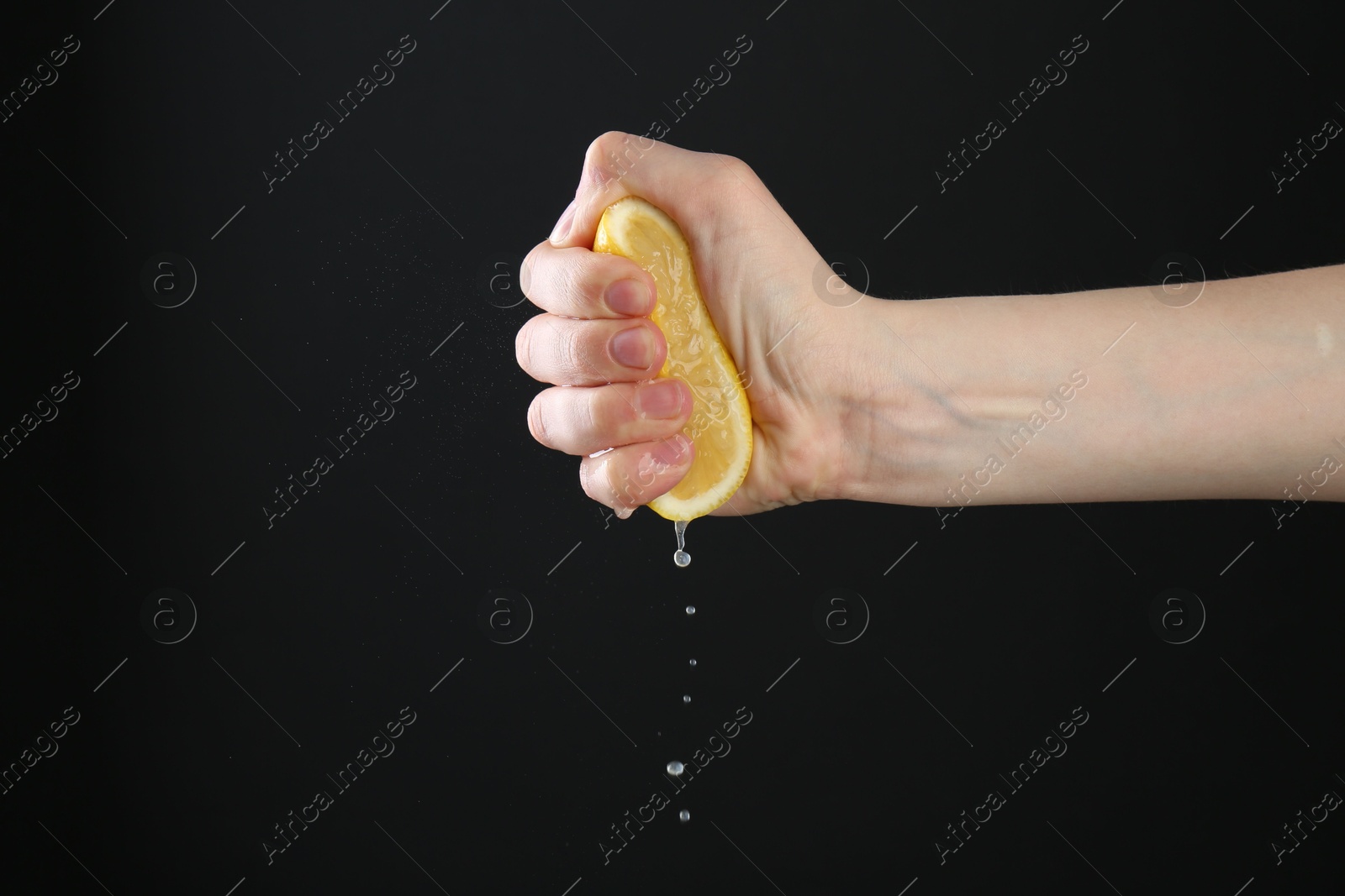 Woman squeezing lemon on black background, closeup. Space for text Photo of Woman squeezing lemon on black background, closeup. Space for text