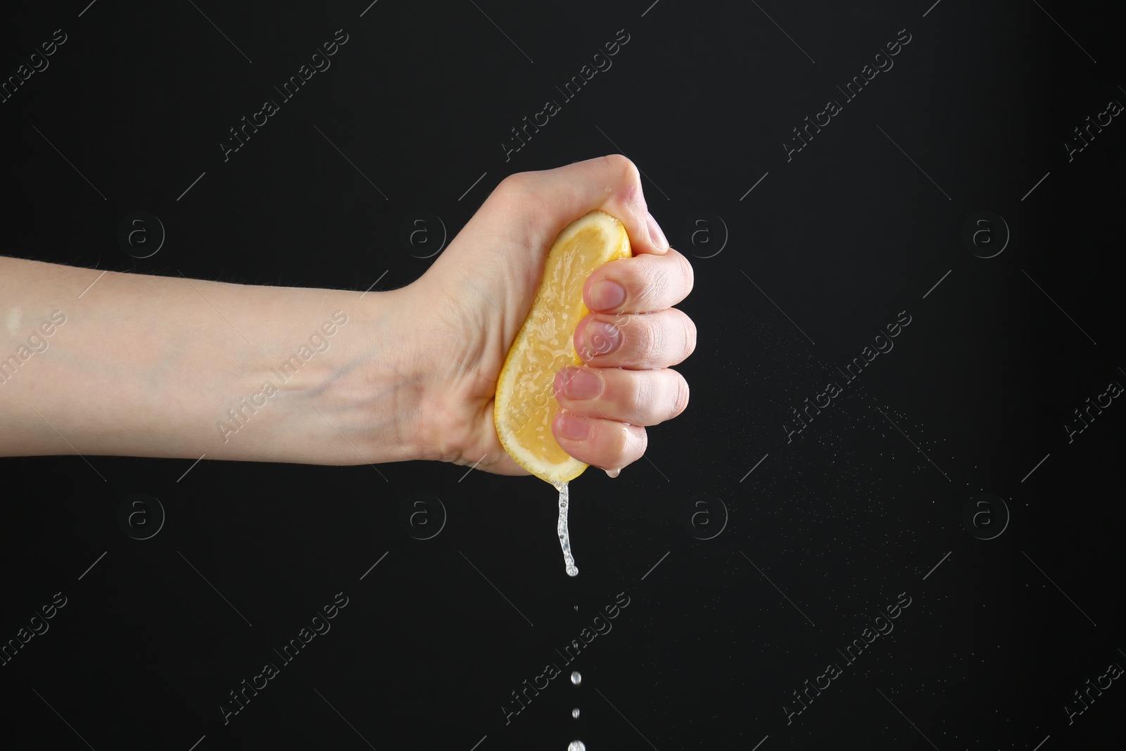 Woman squeezing lemon on black background, closeup. Space for text Photo of Woman squeezing lemon on black background, closeup. Space for text