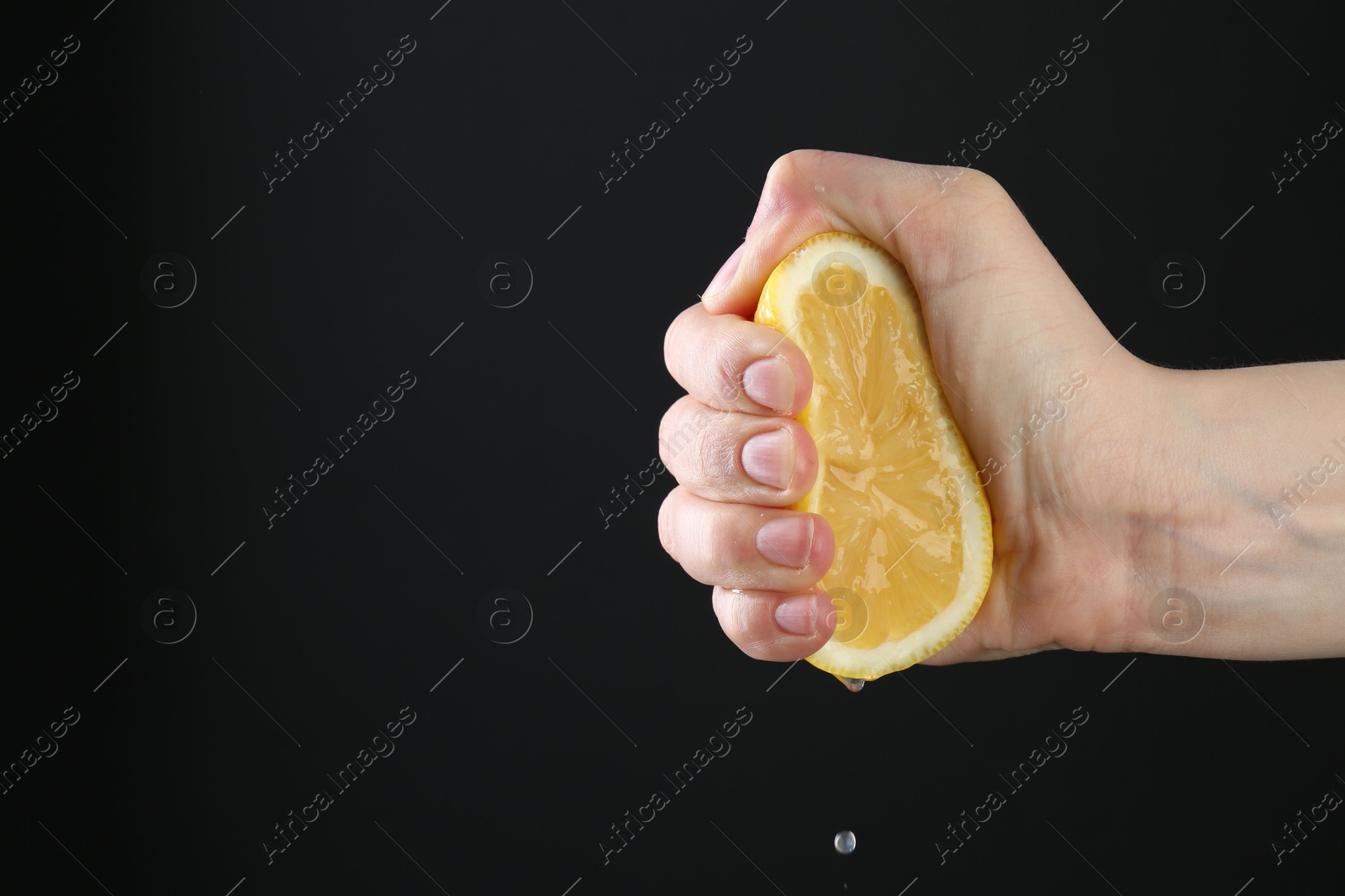 Woman squeezing lemon on black background, closeup. Space for text Photo of Woman squeezing lemon on black background, closeup. Space for text