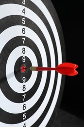 Photo of Targeting. Dart board with arrow on black background, closeup