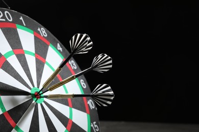 Photo of Targeting. Dart board with arrows on dark background, closeup. Space for text