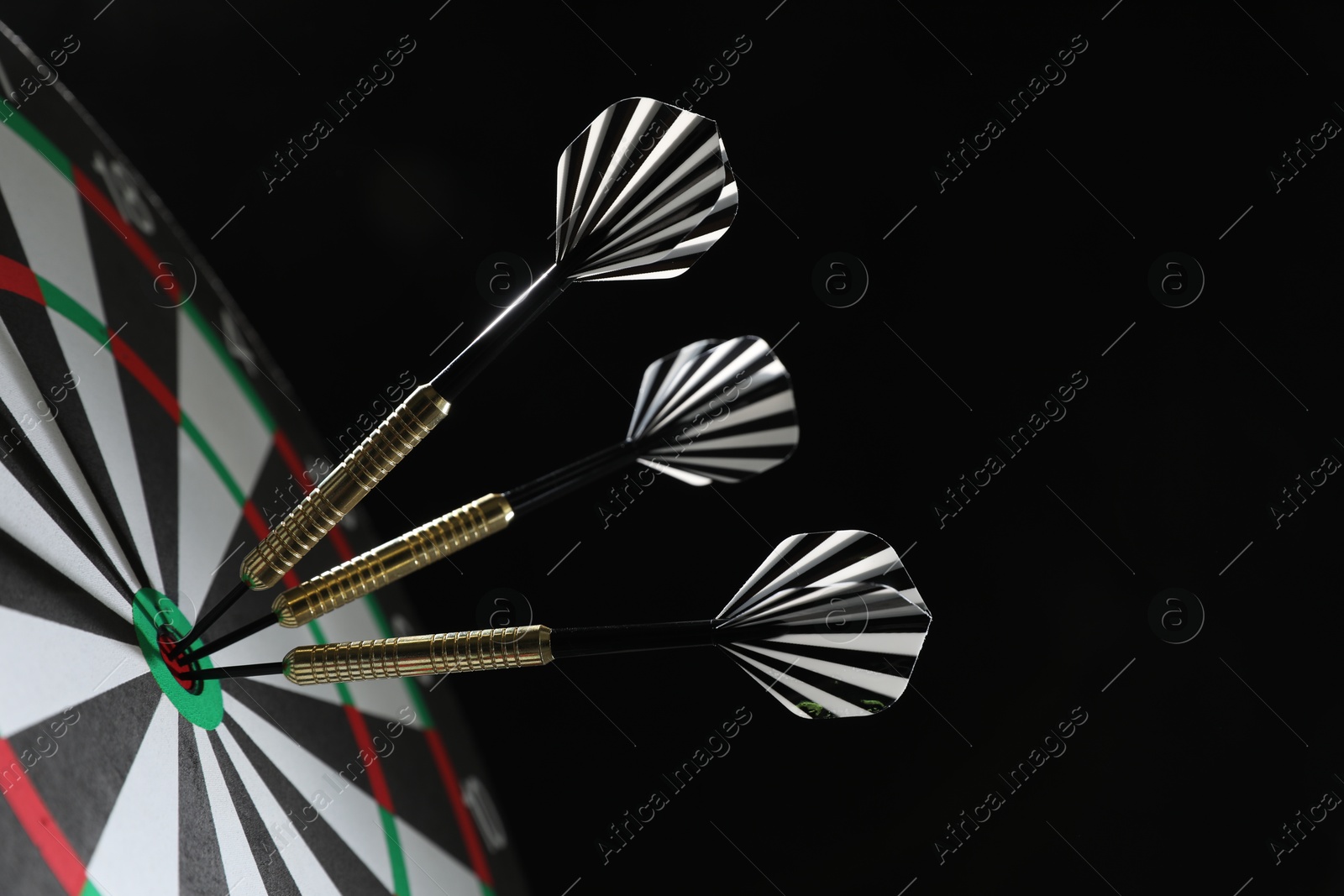 Targeting. Dart board with arrows on black background, closeup Photo of Targeting. Dart board with arrows on black background, closeup