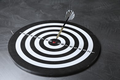 Photo of Targeting. Dart board with arrow on gray textured background