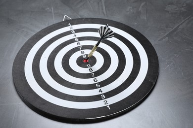 Photo of Targeting. Dart board with arrow on gray textured background