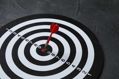 Photo of Targeting. Dart board with arrow on gray background, closeup