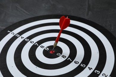 Photo of Targeting. Dart board with arrow on gray background, closeup