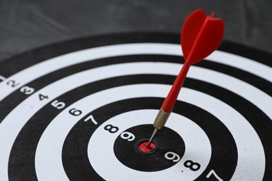Photo of Targeting. Dart board with arrow on gray background, closeup