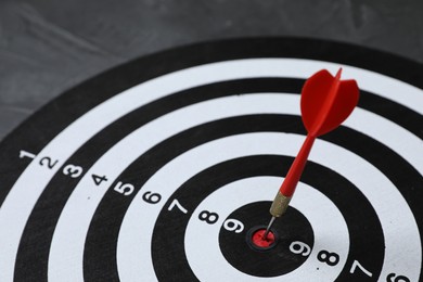Photo of Targeting. Dart board with arrow on gray background, closeup