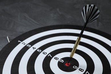 Photo of Targeting. Dart board with arrow on gray background, closeup