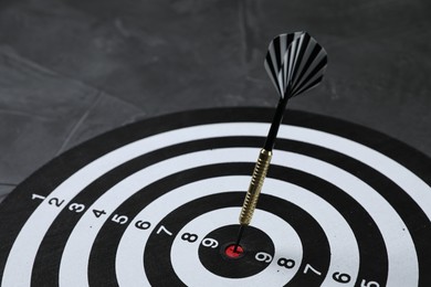 Photo of Targeting. Dart board with arrow on gray background, closeup