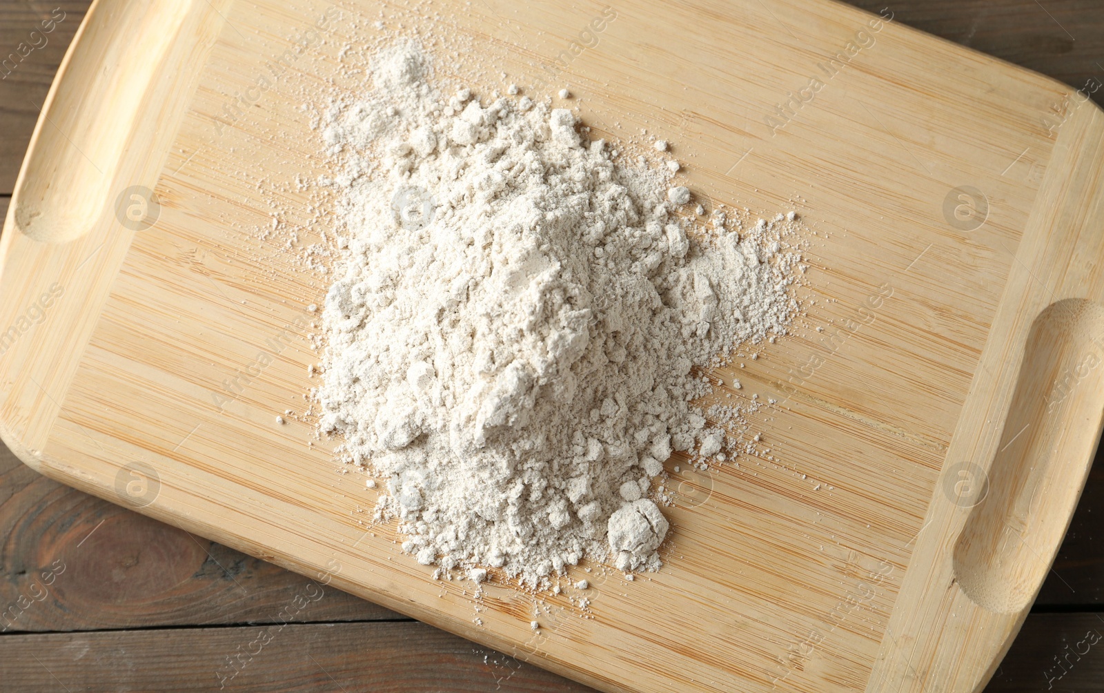 Pile of flour on wooden table, top view Photo of Pile of flour on wooden table, top view