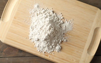 Photo of Pile of flour on wooden table, top view