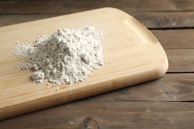 Photo of Pile of flour on wooden table, closeup