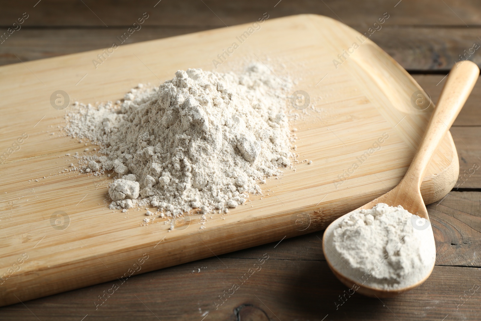 Pile of flour and spoon on wooden table, closeup Photo of Pile of flour and spoon on wooden table, closeup