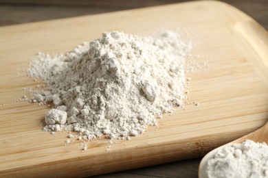 Photo of Pile of flour on wooden table, closeup